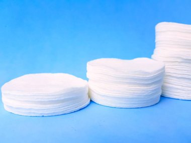 Parlak mavi arka planda yuvarlak pamuk diskler. Kendine dikkat et..