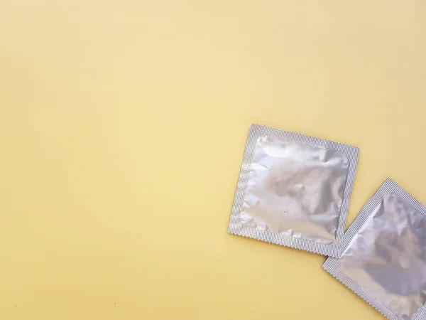 Préservatif sur fond jaune. Le concept de rapports sexuels protégés et de protection contre les infections transmissibles sexuellement. — Photo