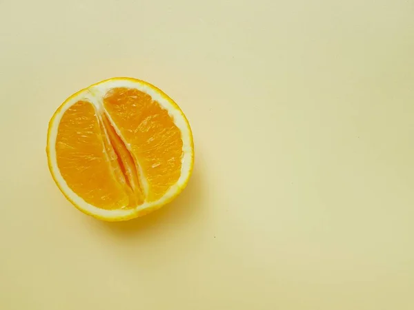 Bright juicy orange on a yellow background. A vagina symbol. The concept of sex. Womens personal hygiene. — Stock Photo, Image