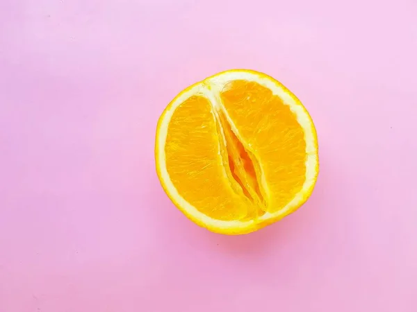 Bright juicy orange on a pink background. A vagina symbol. The concept of sex. Womens personal hygiene. — Stock Photo, Image