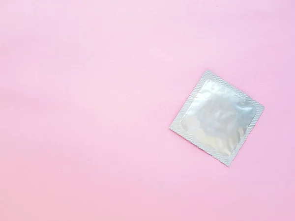 Condón sobre fondo rosa. El concepto de sexo seguro y protección contra infecciones de transmisión sexual. — Foto de Stock