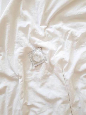 Beyaz arka planda prezervatif. Cinsel yolla bulaşan enfeksiyonlardan korunma ve güvenli seks kavramı.