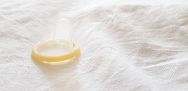 Beyaz arka planda prezervatif. Cinsel yolla bulaşan enfeksiyonlardan korunma ve güvenli seks kavramı.