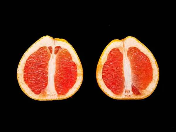 Pomelo jugoso rojo maduro en un corte en una vista de fondo negro desde arriba. El concepto de dieta y alimentación saludable. Un lugar para el texto. —  Fotos de Stock