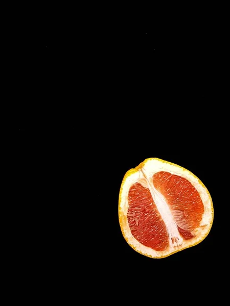 Pompelmo succoso maturo rosso in un taglio su una vista di sfondo nera dall'alto. Il concetto di dieta e alimentazione sana. Un posto per il testo. — Foto Stock