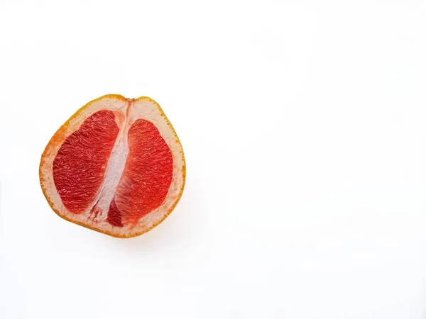 上から白い背景にカットされた赤い熟したジューシーなグレープフルーツ。食事と健康的な食事の概念。テキストの場所. ストック写真