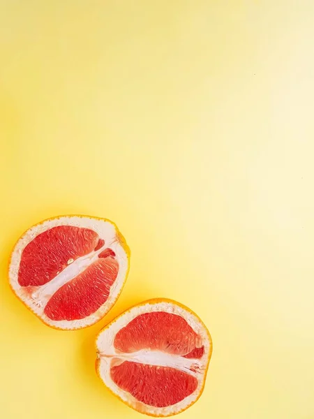Красный спелый сочный грейпфрут в порез на желтом фоне сверху. Концепция питания и здорового питания. Место для текста. — стоковое фото