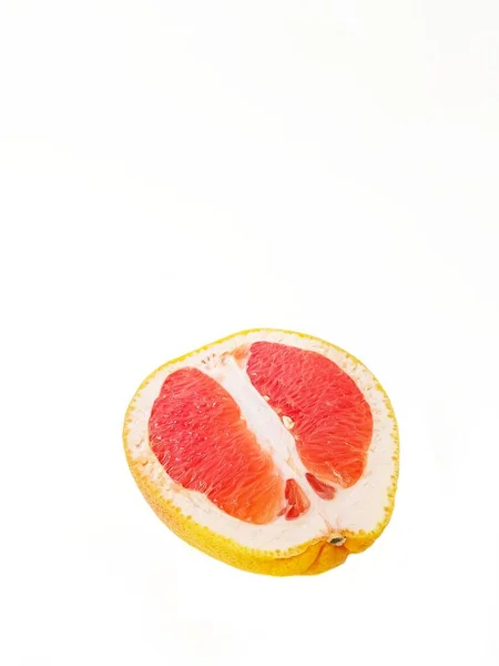 Pomelo jugoso rojo maduro en un corte sobre un fondo blanco. El concepto de dieta y alimentación saludable. Un lugar para el texto. — Foto de Stock