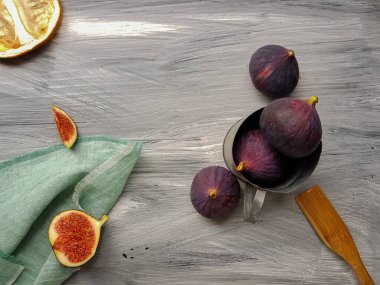 Metal bir kasede koyu bir arka planda olgun mor incirler.. 