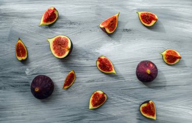 Koyu bir arka planda, ahşap yüzeyde parlak olgun incirler..