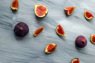 Koyu bir arka planda, ahşap yüzeyde parlak olgun incirler..