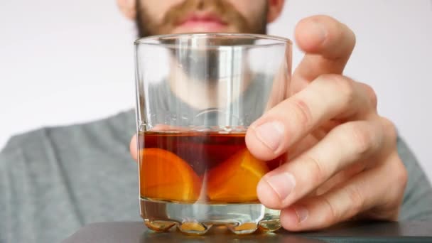 Skäggig Man Tar Ett Glas Whisky Med Citron Och Dricker — Stockvideo