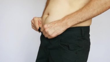 Şişman bir adamın pantolonu bağlamakla ilgili sorunu var.