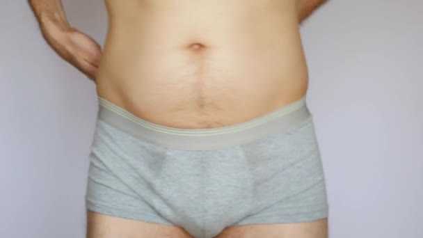 Ein Kleiner Dicker Mann Misst Seine Taille Vor Weißem Hintergrund — Stockvideo