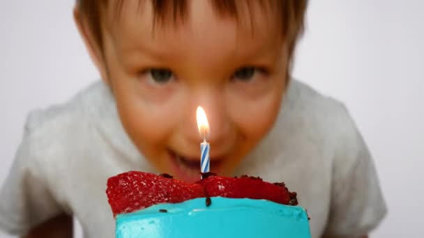 Een Leuke Jongen Probeert Een Kleine Kaars Uit Blazen Een — Stockvideo