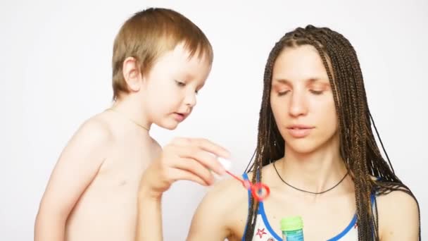 Piękne Warkocze Pani Jej Mały Syn Wieje Bańki Mydła Białym — Wideo stockowe