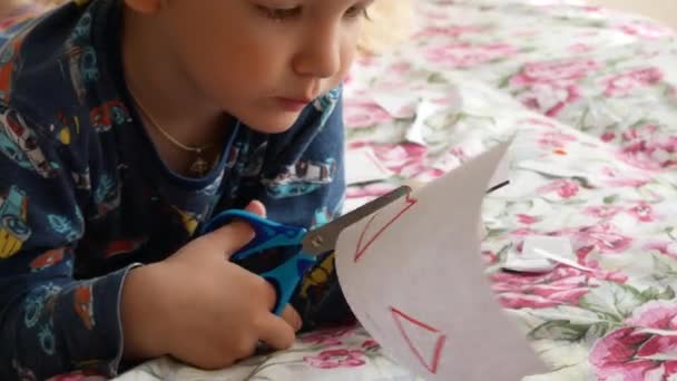 Ένα Μικρό Αγόρι Κόβει Προσεκτικά Γεωμετρικές Φιγούρες Από Χαρτί Ψαλίδι — Αρχείο Βίντεο