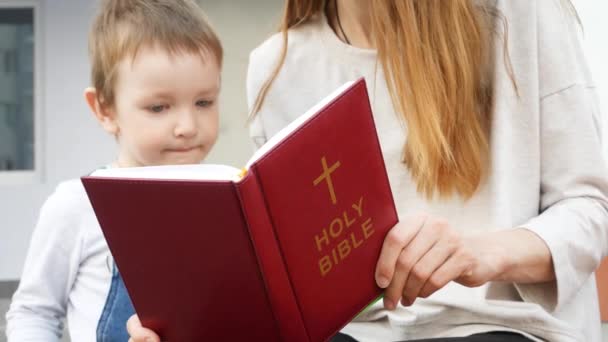 Μια Όμορφη Γυναίκα Διαβάζει Την Αγία Γραφή Για Τον Μικρό — Αρχείο Βίντεο