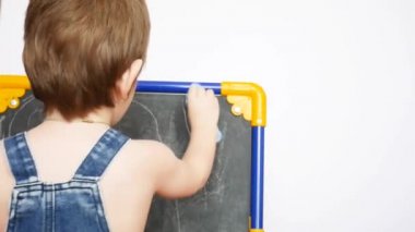 Küçük bir çocuk çizim tahtasını yıkıyor.