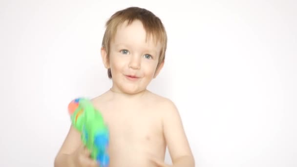 Een Vrolijk Jongetje Schiet Met Een Waterpistool — Stockvideo