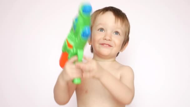 一个快乐的小男孩拿着水枪笑着射击 — 图库视频影像