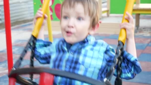 Niño Encantador Con Una Camisa Cuadros Azul Balancea Patio Recreo — Vídeos de Stock