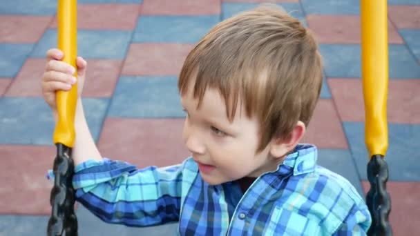Niño Encantador Con Una Camisa Cuadros Balancea Patio Recreo — Vídeos de Stock