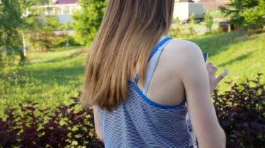 Güzel bir kız dışarıda dolaşırken tabletini kullanıyor.