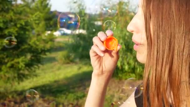 Pretty Young Lady Blows Some Soap Bubbles Outdoors — Stock Video