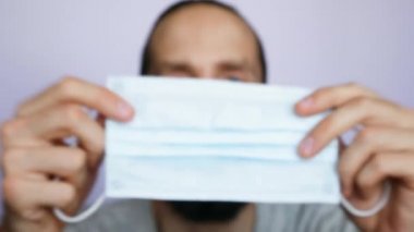 Çekici bir genç adam koruyucu yüz maskesi takıyor.