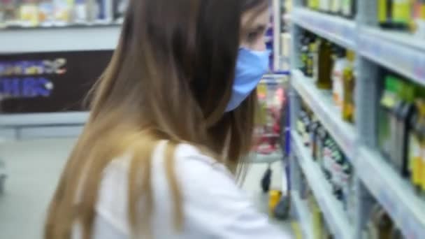 Eine Junge Frau Mit Schutzmaske Wählt Supermarkt Ein — Stockvideo