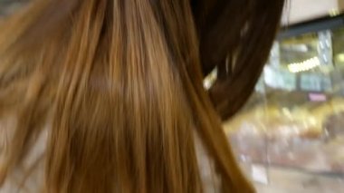 Koruyucu maske takan güzel bir kız süpermarketteki tezgahtan çörek alıyor.