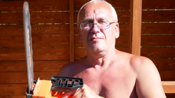 Ένας Ηλικιωμένος Άνδρας Ηλεκτρικό Πριόνι Στέκεται Πάνω Ξύλινη Βεράντα — Αρχείο Βίντεο