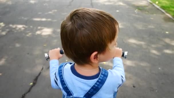 Een Kleine Jongen Rijdt Een Kleine Fiets Een Weg Kijkt — Stockvideo