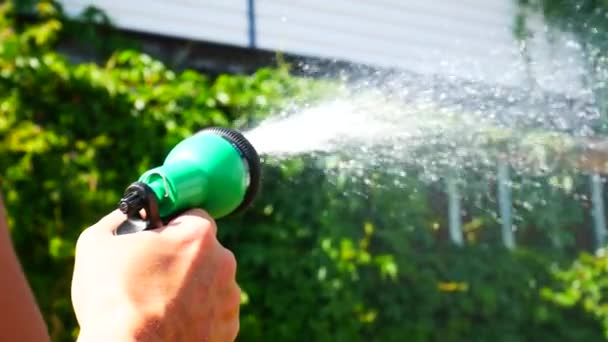 Människans Hand Håller Vattning Spray Och Vatten Växter Nära Huset — Stockvideo