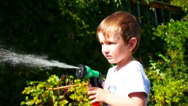 Ένα Υπέροχο Αγόρι Μένει Στον Κήπο Και Ποτίζει Φυτά — Αρχείο Βίντεο