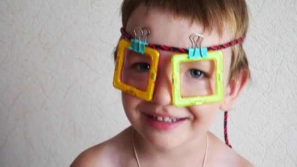 Ein Kleiner Junge Amüsiert Sich Mit Einer Handgemachten Spielzeugbrille Gesicht — Stockvideo