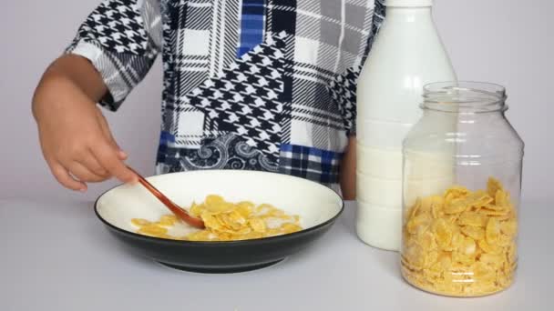 Liten Pojke Äter Frukost Majsflingor Med Mjölk Nära Håll — Stockvideo