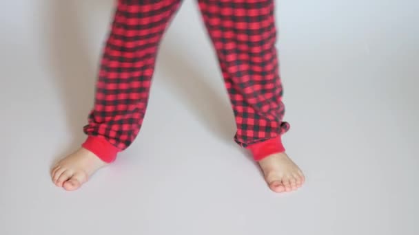 Niño Vistiendo Pantalones Rojos Cuadros Grandes Pasos Pie Sobre Superficie — Vídeos de Stock