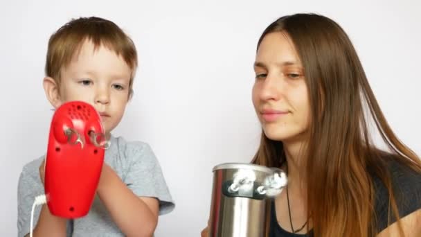 Egy Kisfiú Fiatal Anyukája Két Különböző Mixert Tartanak Kezükben Fehér — Stock videók