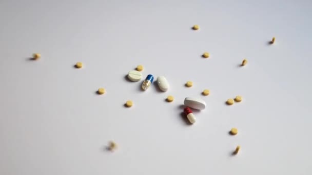 Muitas Pílulas Cápsulas Diferentes Derramando Uma Superfície Branca — Vídeo de Stock