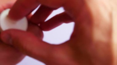 Bir adamın eli beyaz bir yüzeye birçok farklı ilaç döker.