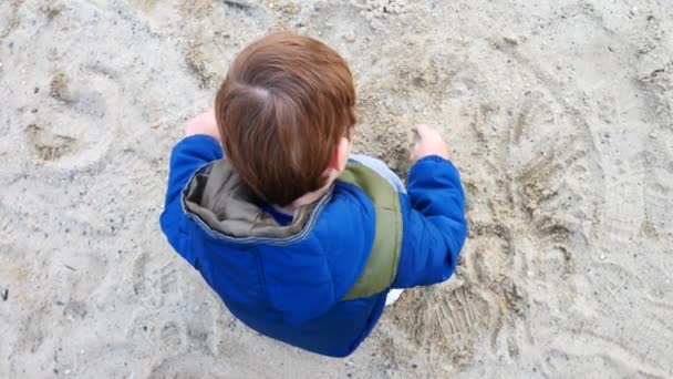 Lille Dreng Iført Jakke Leger Med Sandet Hugsiddende – Stock-video