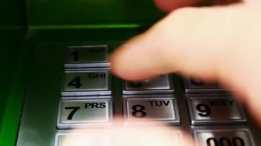 Bir kadının eli ATM klavyesindeki kodu çevirir.