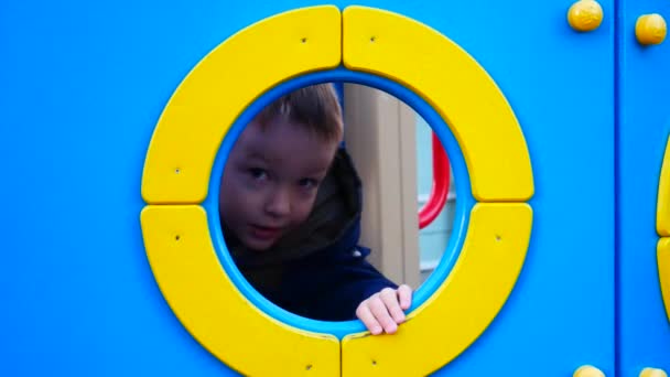 Happy Boy Has Fun Sticking His Head Hole Playground Outdoors — Stock Video