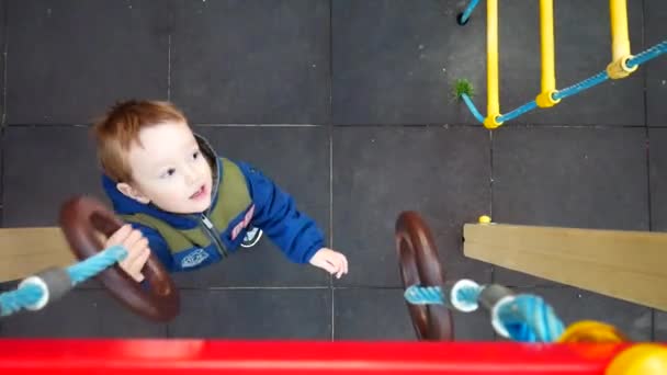 Een Mooi Jongetje Heeft Plezier Aan Atletische Ringen Een Speeltuin — Stockvideo