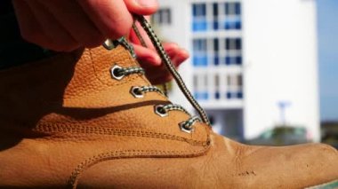 Deri çizme bağlayan bir kadının yan görüntüsü.