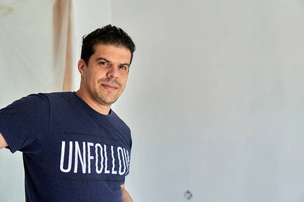 Bir odayı boyarken mavi gömlekli bir işçinin portresi