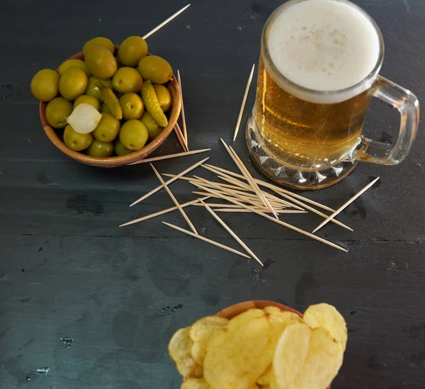 Zeytinli bira ve siyah bir tabanda patates.