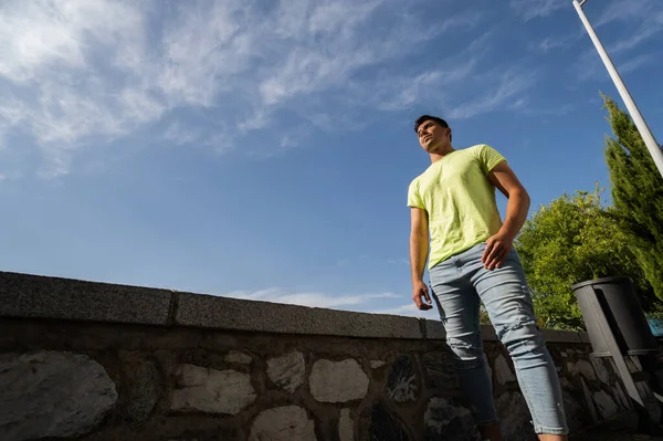 Toledo 'ya tepeden bakan yeşil tişörtlü ve açık mavi gökyüzlü bir çocuk.